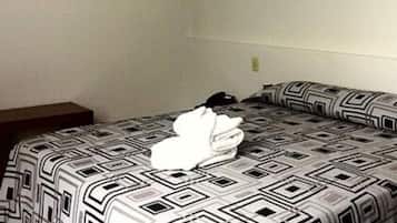 Habitación de hotel con cama, mesita de noche y un cuadro colgado en la pared.