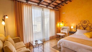 Une chambre d’hôtel avec un lit, un canapé, un bureau et une lampe.