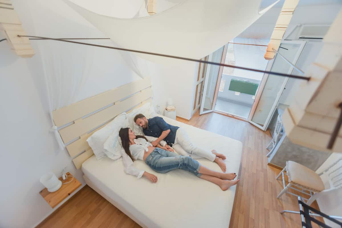 Ein Schlafzimmer mit einem Bett, einem Nachttisch und einem Fenster.