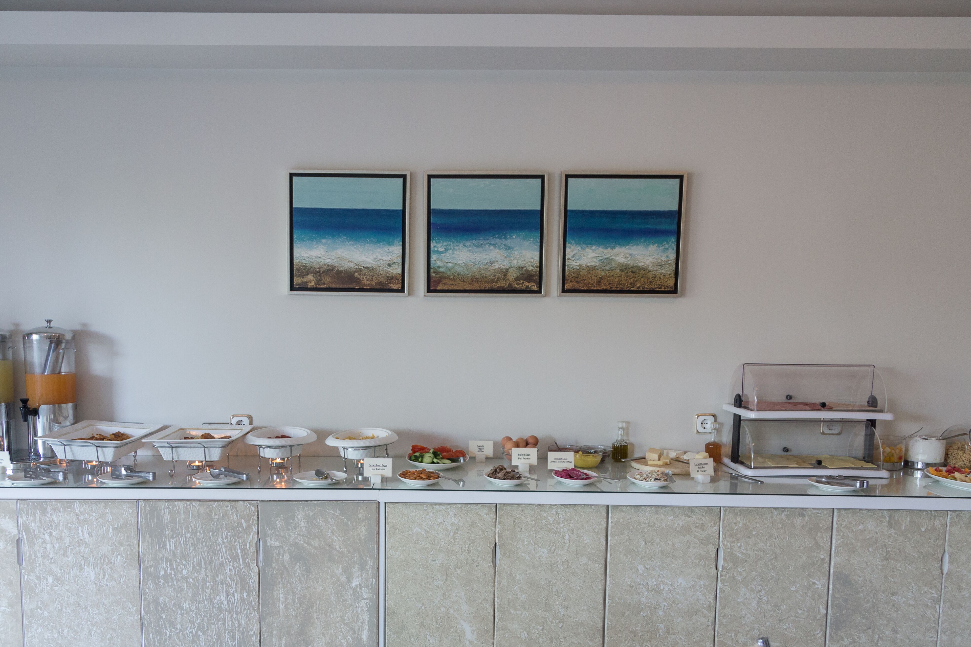 A buffet setup with various food items and a coffee machine.