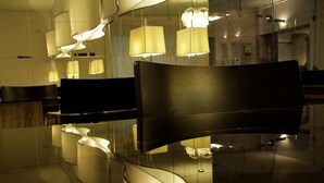 A modern interior with reflective surfaces, contemporary furniture, and ambient lighting. - Crillon Mendoza (Mendoza)