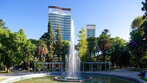 A fountain in a park with tall buildings in the background. - Crillon Mendoza (Mendoza)