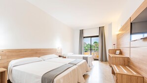 Une chambre d’hôtel avec deux lits, un bureau, une télévision et un balcon avec vue.