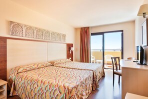 A hotel room with two beds, a desk, a chair, and a balcony with a view. - Hotel Best Alcazar (Almunecar)