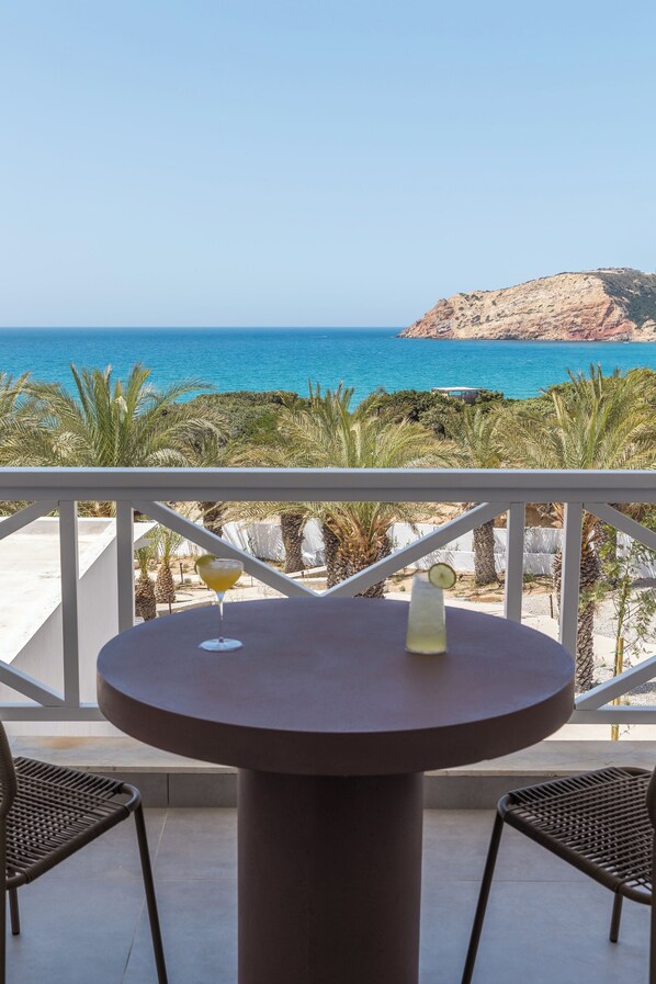 A round table with two chairs on a balcony overlooking the sea. - Golden Milos Beach House by Domotel (Milos)