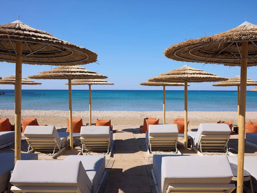 Privat strand, hvit sand, solsenger og parasoller