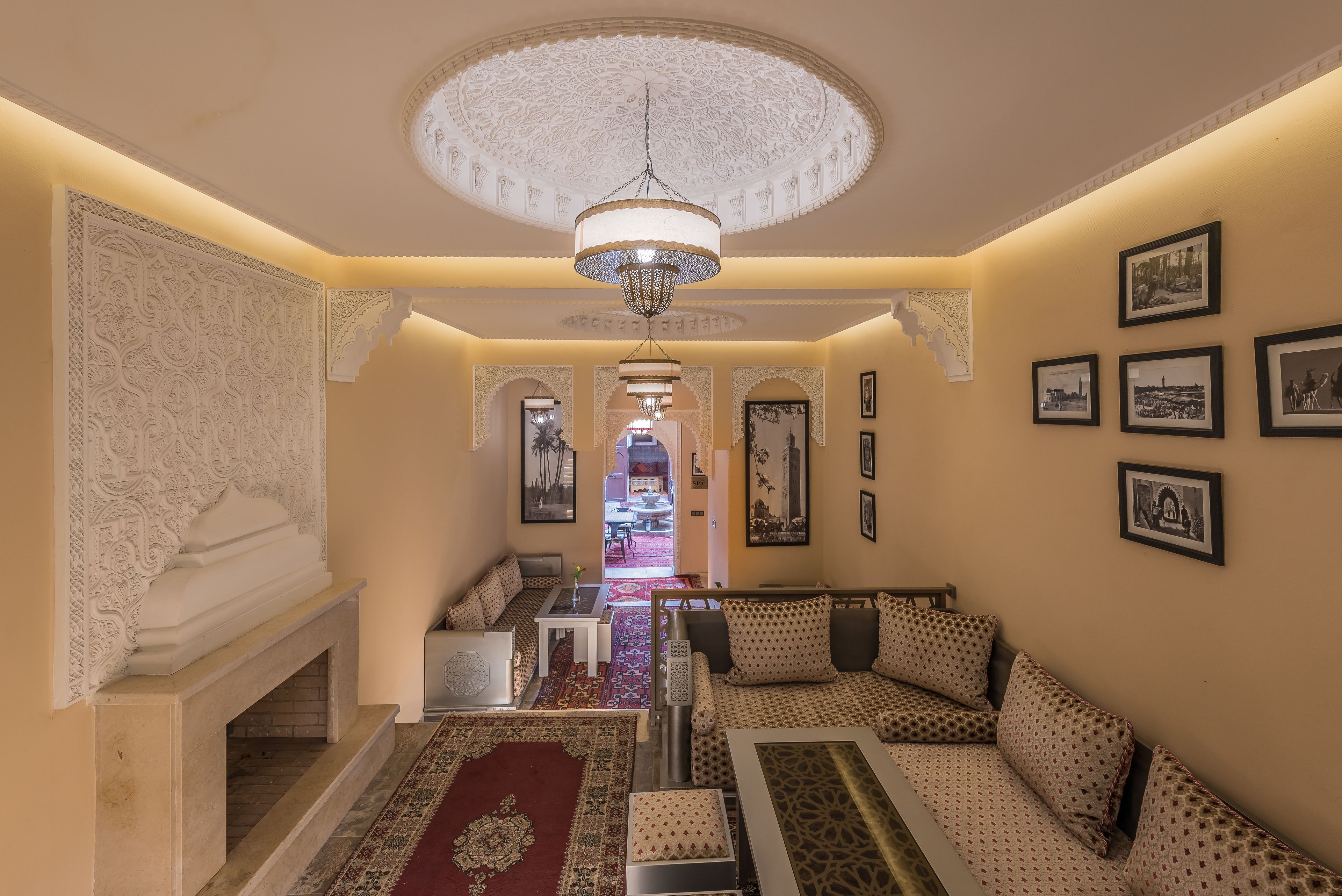 A spacious living area with a fireplace, patterned sofas, and a chandelier.