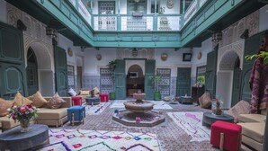 A spacious courtyard with a fountain, seating areas, and intricate tile work. - Riad Les Oliviers & Spa (Marrakech)