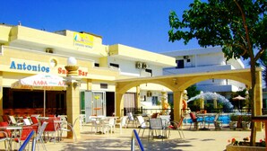 A hotel with outdoor seating and a pool area. - Antonios Hotel (Rhodes)