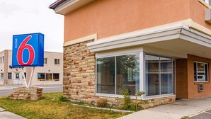 Ein Motel mit einem großen Schild mit der Zahl 6, einer Ziegel-Fassade und einem modernen Glas Eingang.