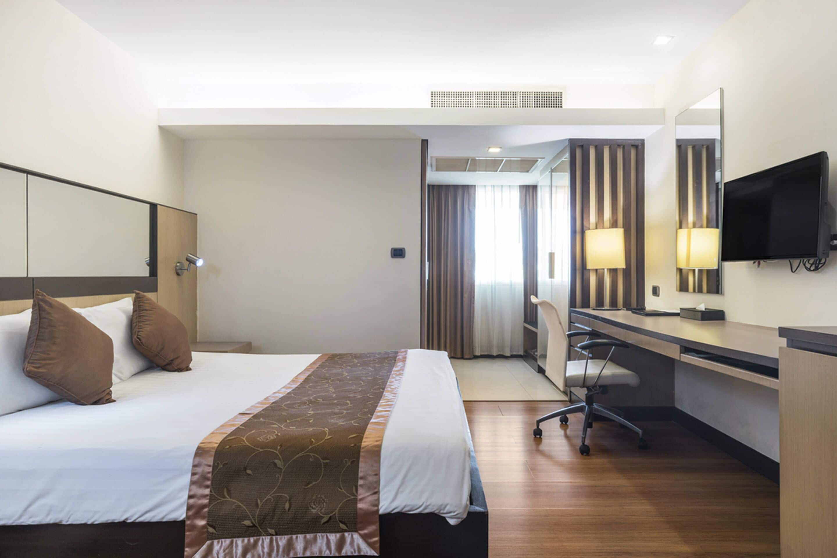 Une chambre d’hôtel équipée d’un lit, d’un bureau, d’une chaise et d’un téléviseur.