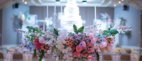 Mesa para recepción de boda con pastel de varios niveles y arreglos florales.