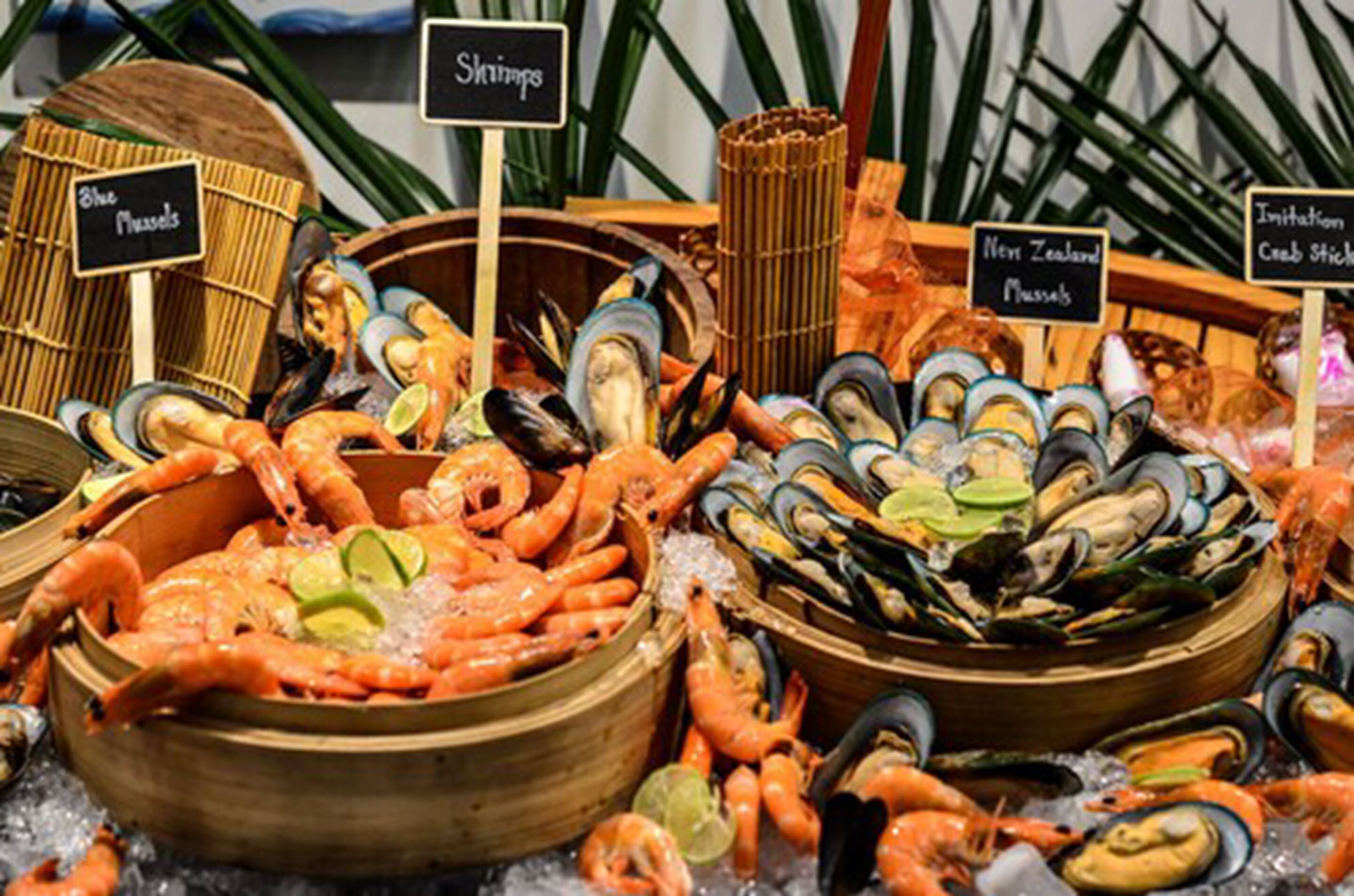 Esposizione di prodotti ittici con diverse varietà di crostacei, tra cui gamberi, cozze e ostriche, disposti su ghiaccio.