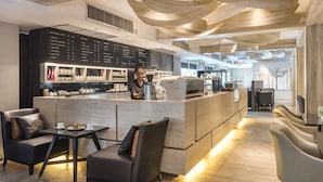 A modern cafe with a bar area, seating, and a menu board. - SC Park Hotel (Bangkok)
