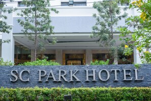 A hotel entrance with a stone sign reading "SC PARK HOTEL". - SC Park Hotel (Bangkok)