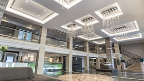 A spacious lobby with a reception desk, seating area, and a staircase. - SC Park Hotel (Bangkok)