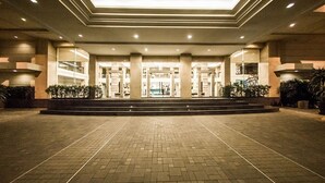 A hotel entrance with a tiled pavement, a central staircase, and a glass facade. - SC Park Hotel (Bangkok)