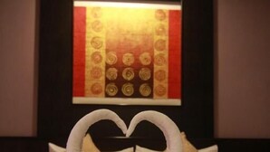 A hotel room with a bed, pillows, and a wall with a decorative pattern. - Grand Pinnacle (Bangkok)