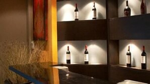 A bar area with shelves displaying bottles of wine. - Grand Pinnacle (Bangkok)