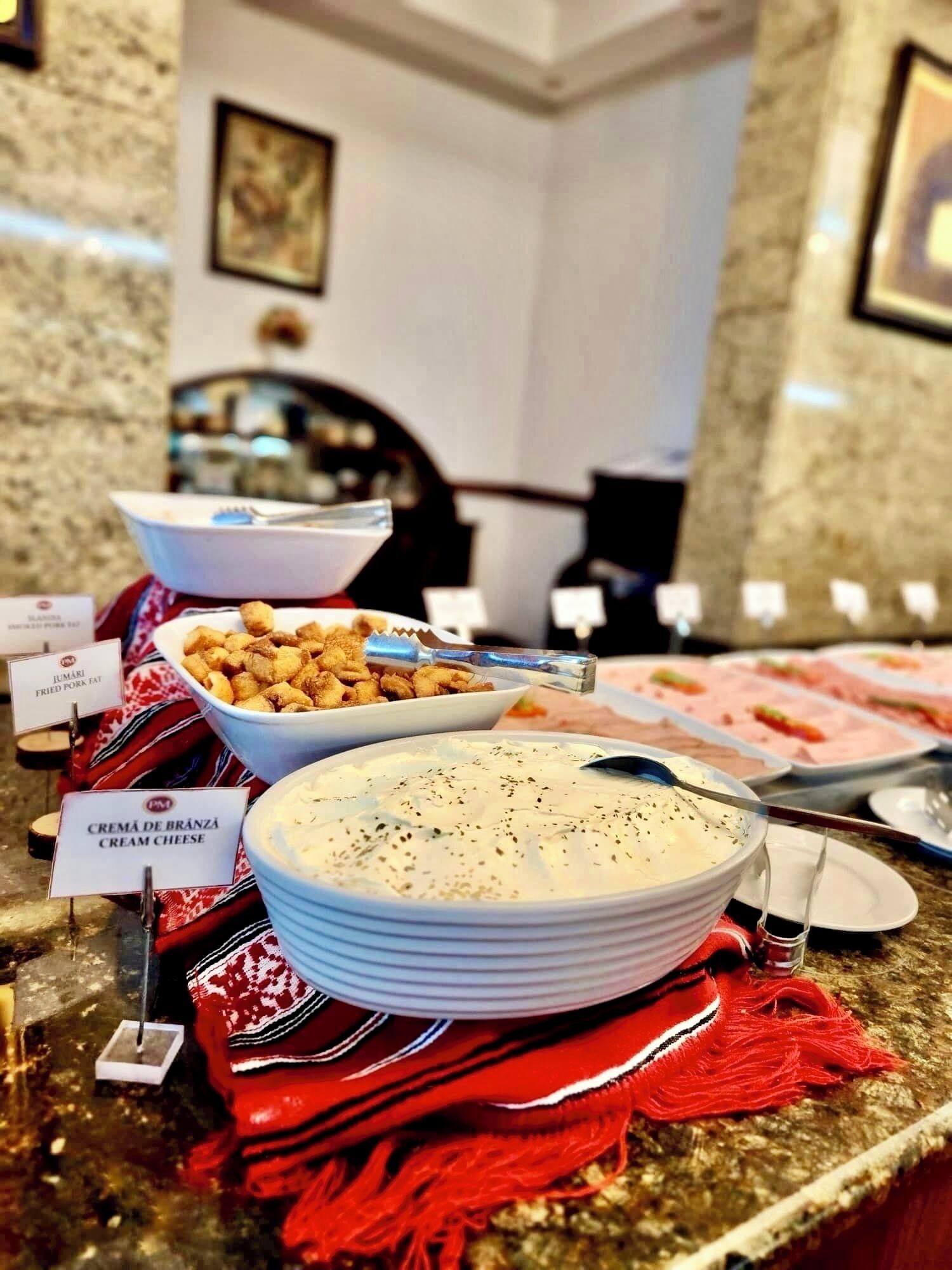 A buffet with labeled dishes including fried pork and cream cheese.