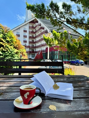 A book, a red cup, and a wooden bench. - Hotel Piatra Mare (Brasov)