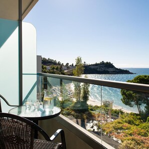 A balcony with a glass table, two chairs, and a pitcher of water. - Mediterranee (KEFALONIA)
