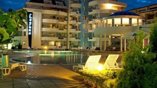 A multi-story hotel with a swimming pool, lounge chairs, and a covered area. - Laguna Holiday (Sunny Beach)