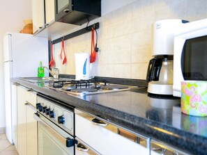 A kitchen with a stove, microwave, and coffee maker.