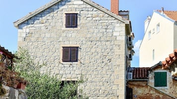 A stone building with two windows and a chimney.