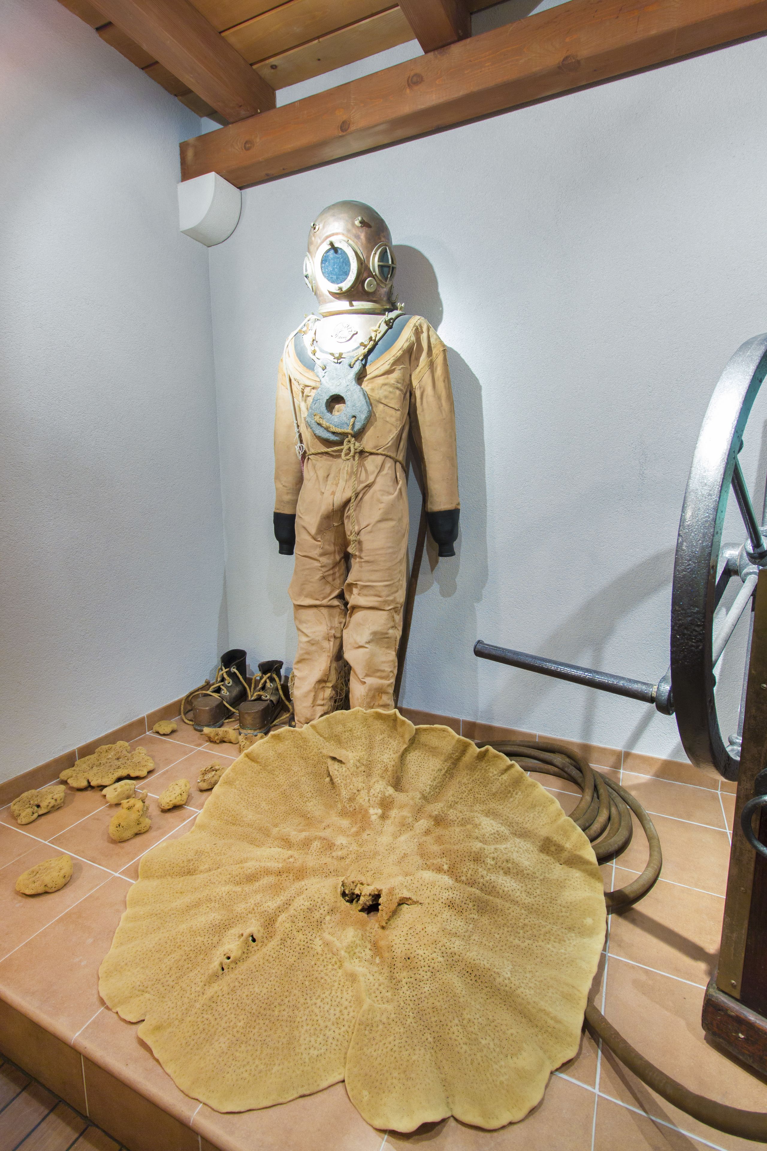 A room with a large, flat, yellow object on the floor, a wooden beam ceiling, and a white wall.