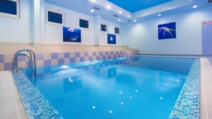 An indoor swimming pool with clear blue water, tiled walls, and ceiling lights. - Hotel Spongiola (Sibenik)