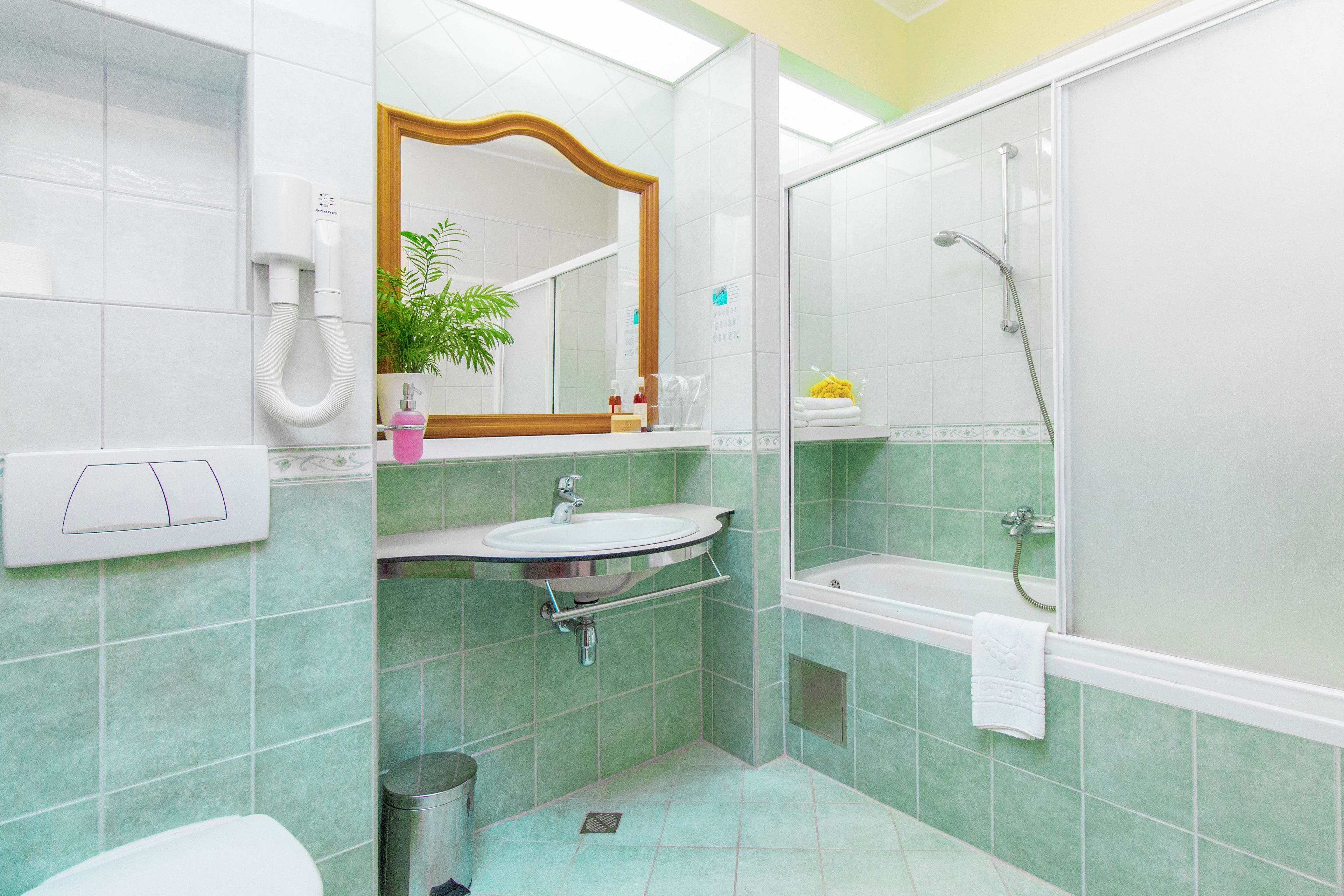 A bathroom with a sink, mirror, and shower.
