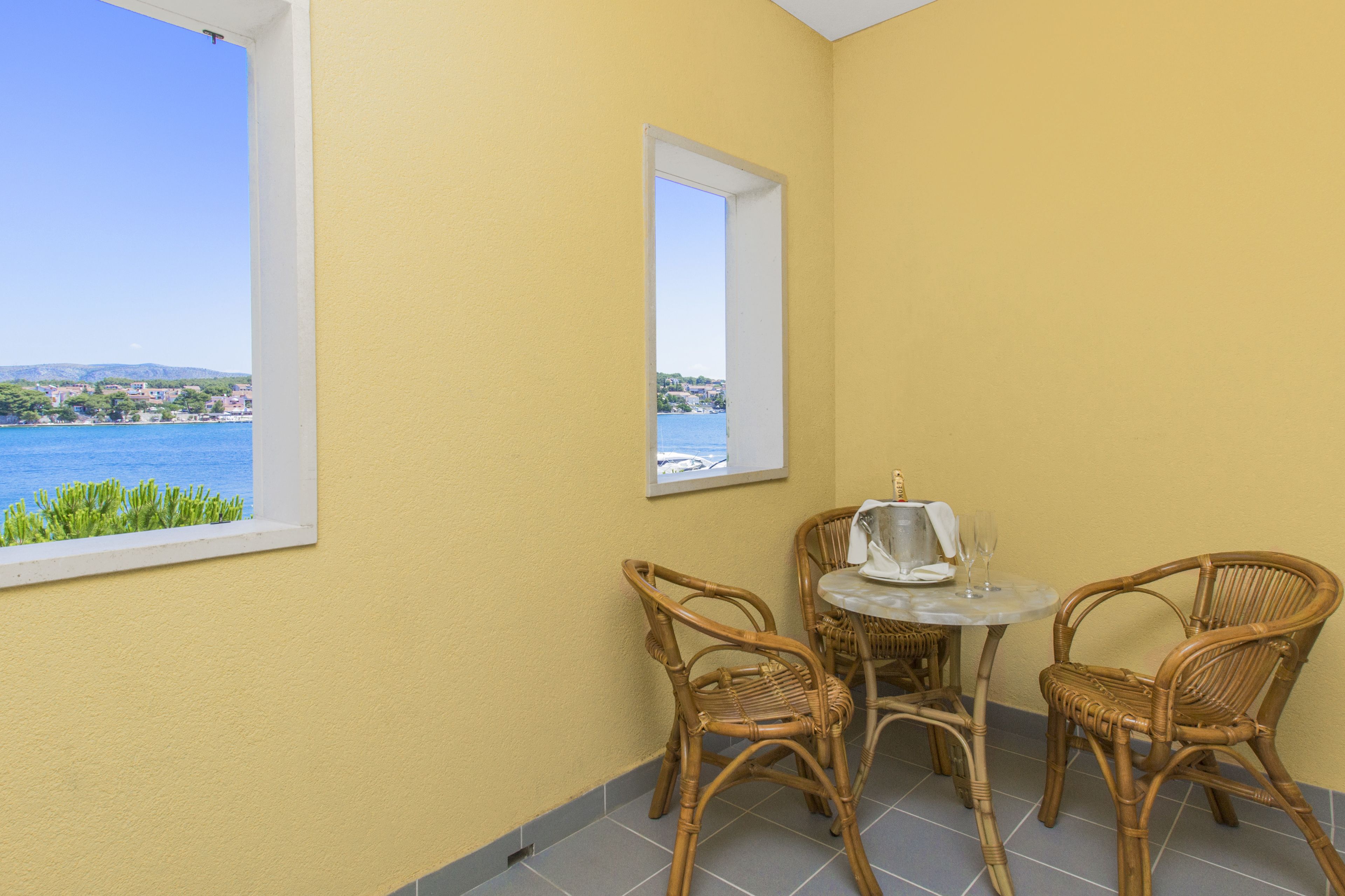 Een hoekzaal met uitzicht op zee, een tafel met stoelen en een raam.