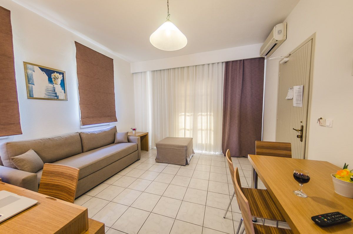 Una sala de estar moderna con un sofá, un reposapiés, una mesa de comedor y un cuadro en la pared.