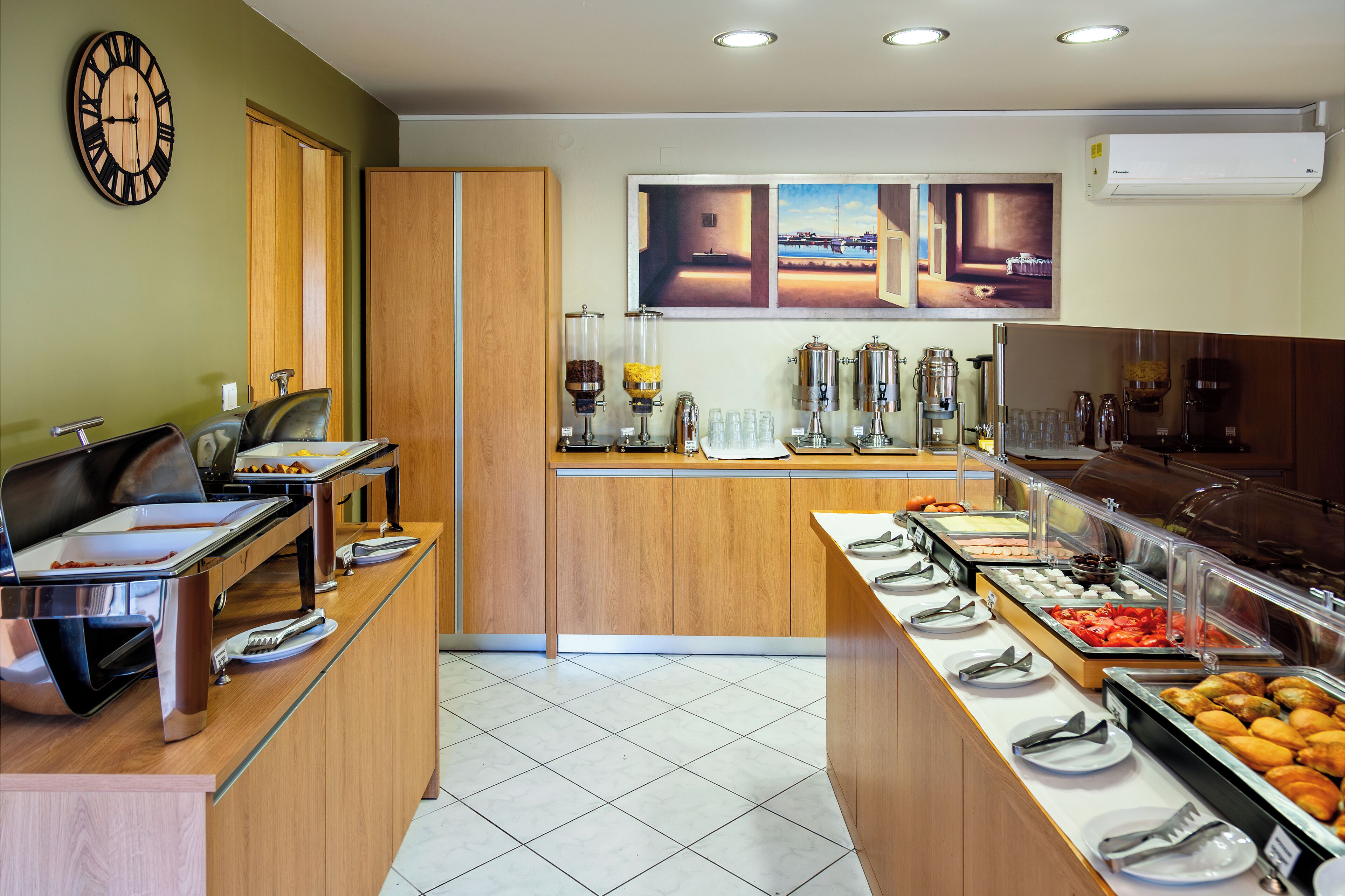 A buffet setup with various food items and a clock on the wall.