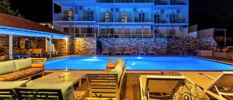 Ett hotell med flera våningar, en swimmingpool, utomhusplats och ett takförsett område.