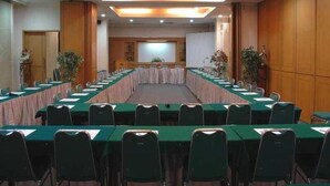 A conference room with a long table, chairs, and a projector screen. - Paragon Gallery Hotel Jakarta (Jakarta)