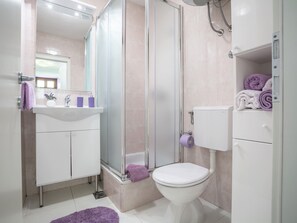 A modern bathroom with a shower, toilet, and sink. - Apartmani Zekan (Split)