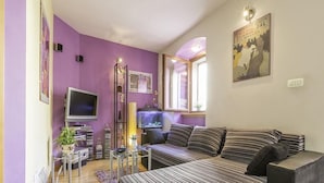 Una habitación con una cama grande, televisión, escritorio y silla.