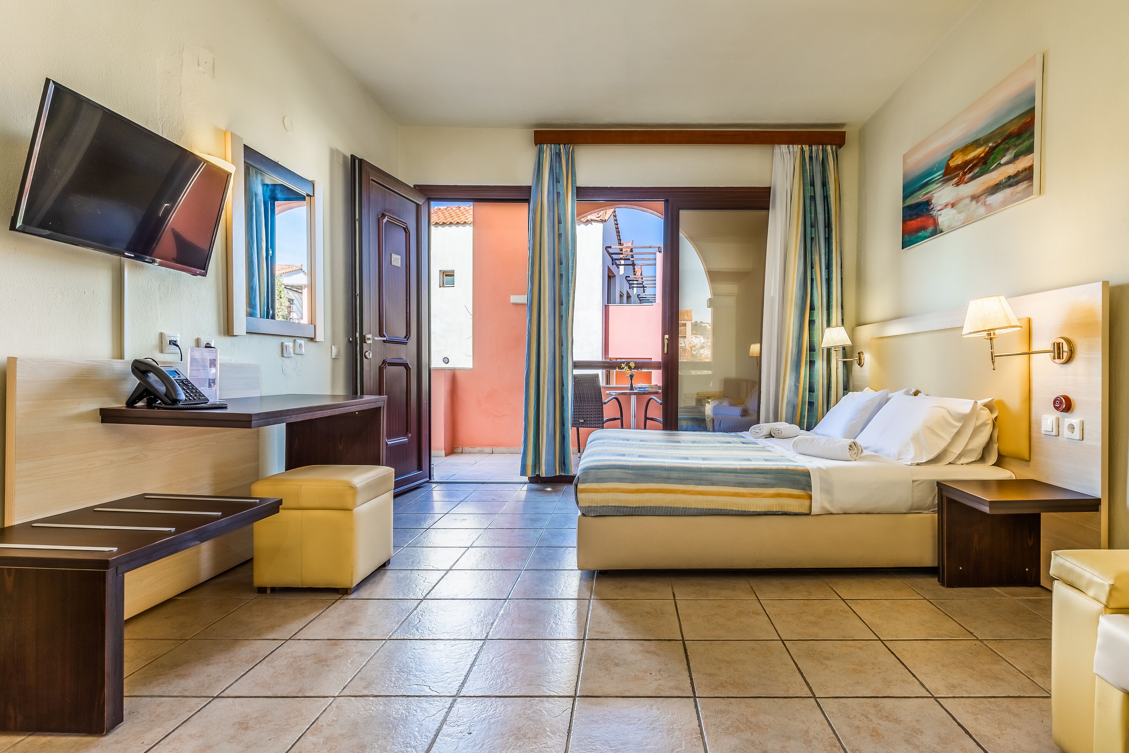 Une chambre d’hôtel avec un lit, un bureau, une télévision et une salle de bain.