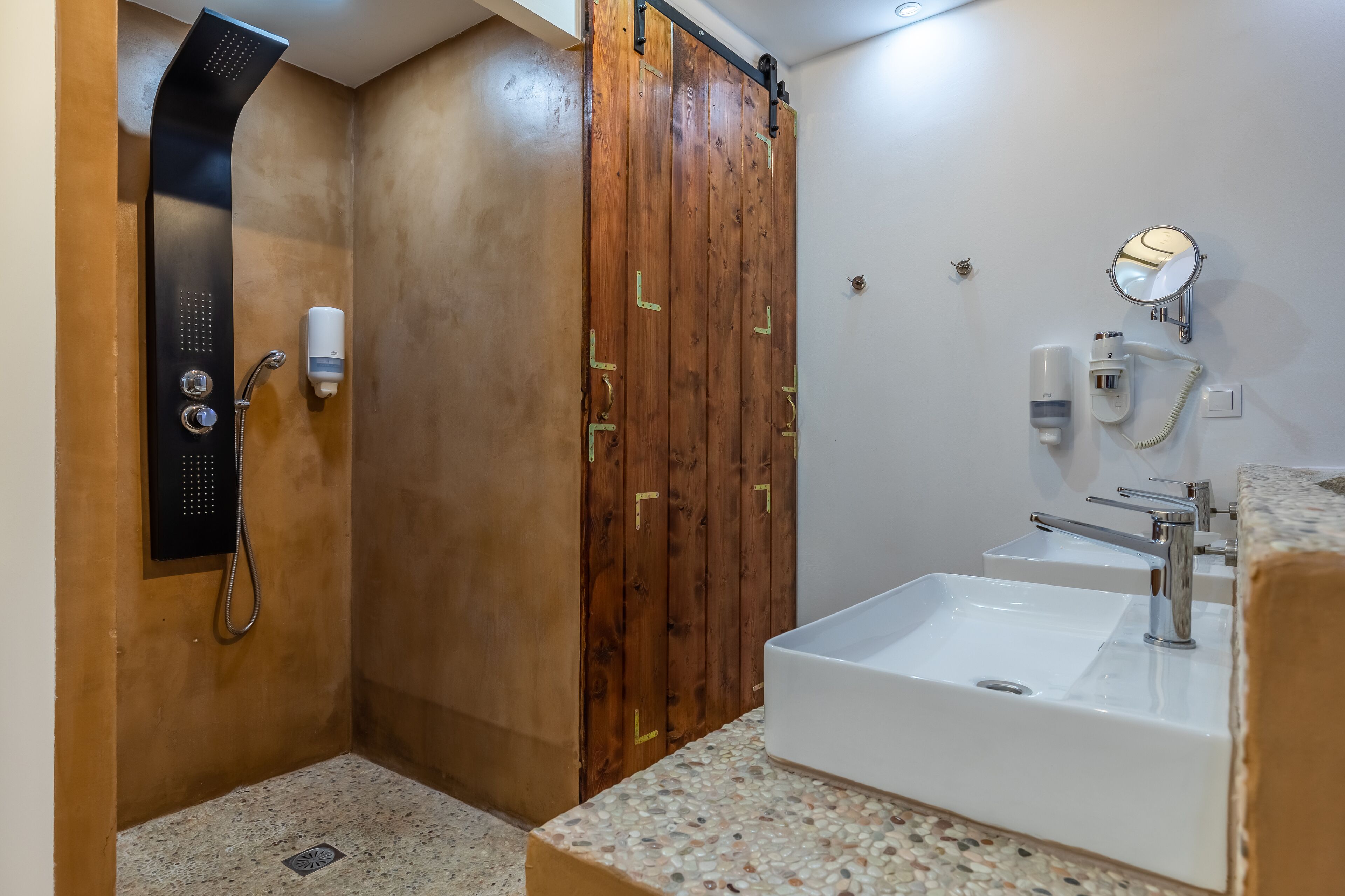 A bathroom with a shower, a sink, and a mirror.