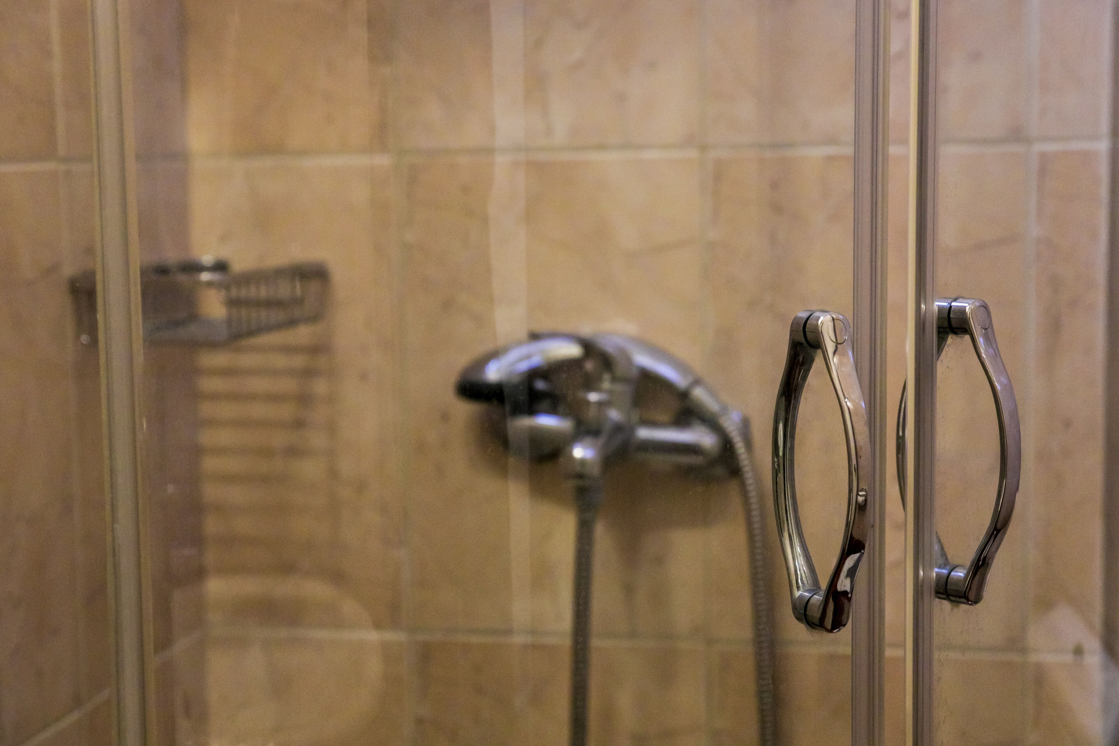 A shower with a glass door and a towel rack.