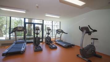 A gym with treadmills, elliptical machines, and stationary bikes.