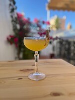 A cocktail in a stemmed glass on a wooden table.