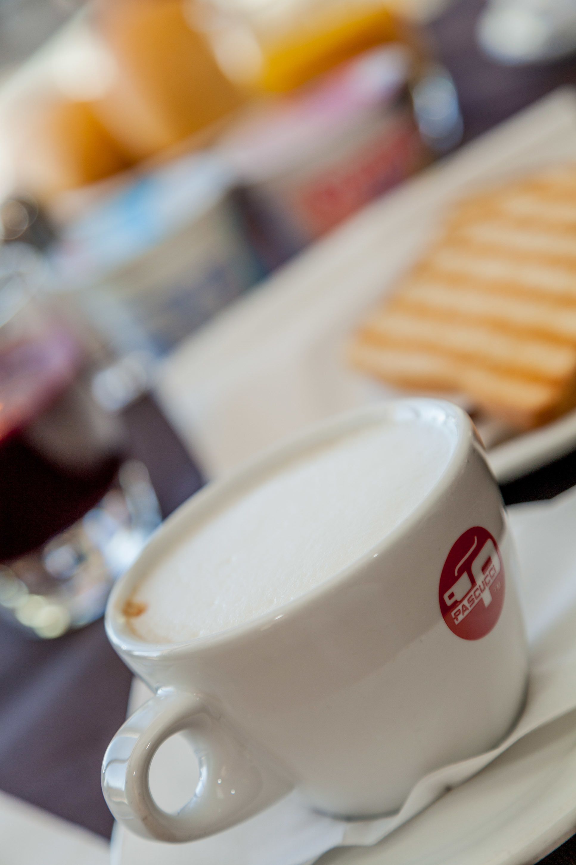 Gros plan d’une tasse blanche ornée d’un logo, posée sur une serviette blanche.