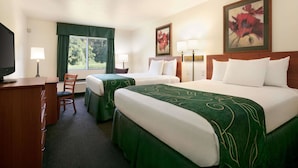 Une chambre d’hôtel avec deux lits, un bureau, une chaise et un téléviseur.