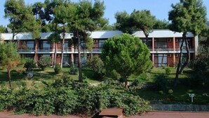 A building with a modern architectural design, featuring a series of windows and a flat roof. - Troia Tusan Hotel (Çanakkale)