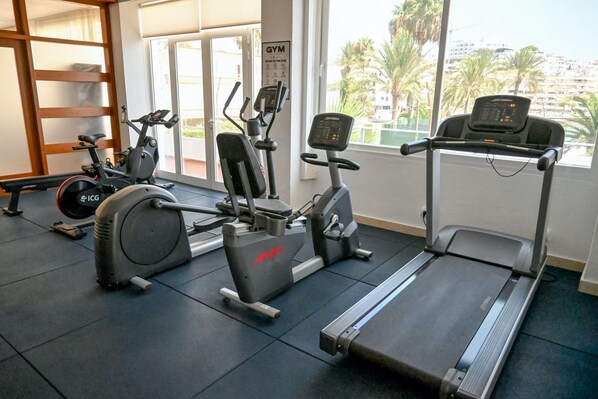 A gym with cardio machines, a treadmill, and a wall-mounted sign. - Hotel Ibiza Playa (Ibiza Town)