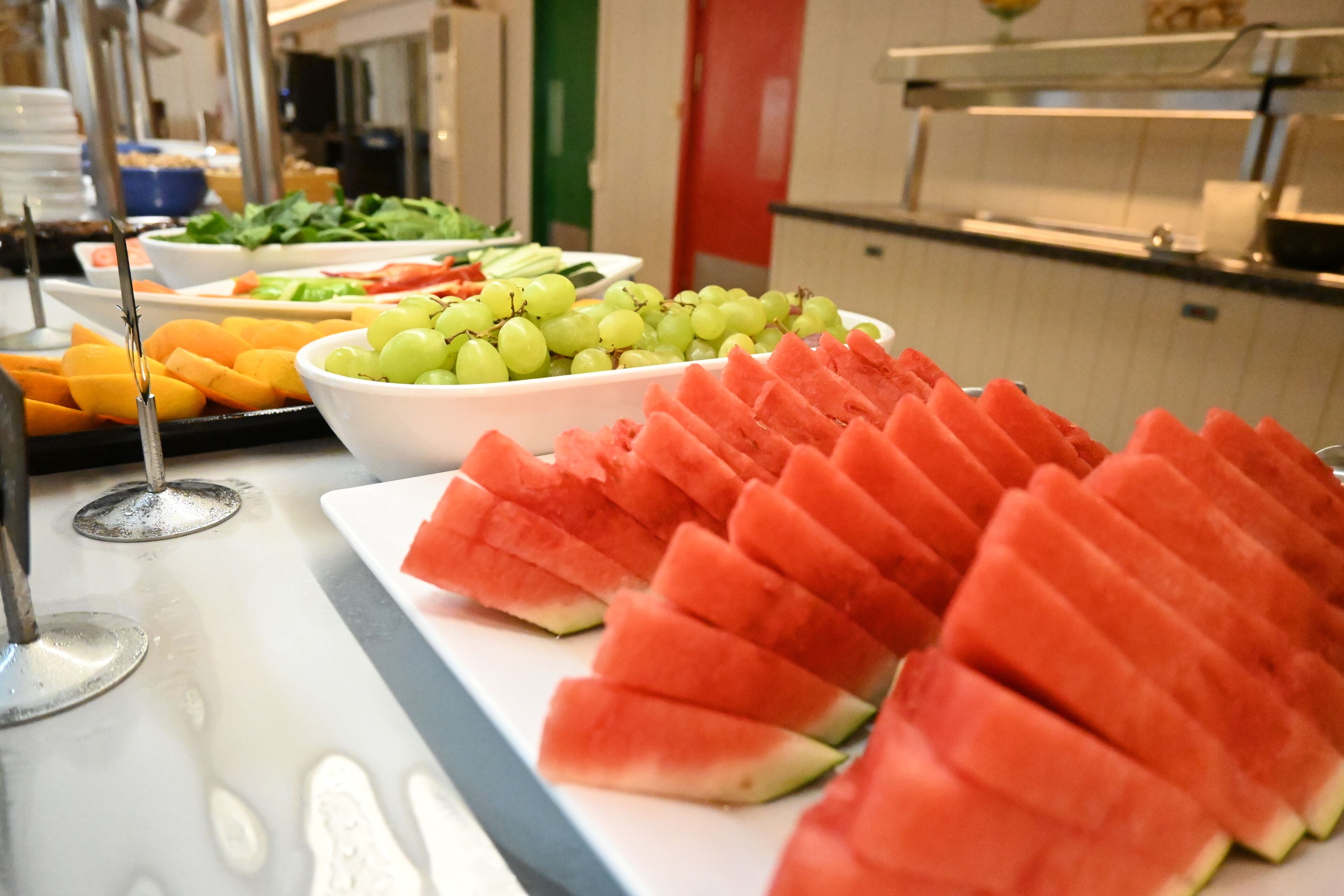 Ein Buffet mit einer Auswahl an Früchten und Gemüse, darunter Wassermelone und Trauben.