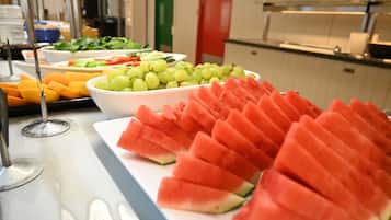 A buffet with various fruits and vegetables, including watermelon and grapes.
